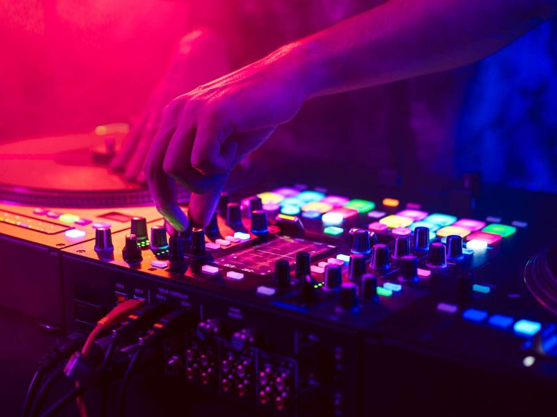 Close up of DJ hands on dj console mixer during concert in the club Close up of DJ hands on dj console mixer during concert in the club