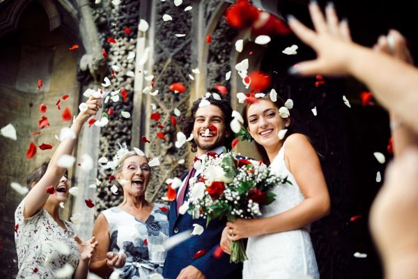 Family throwing rose petals at the newly wed bride and groom Family throwing rose petals at the newly wed bride and groom