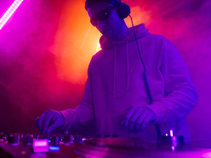 Male DJ playing music in the night club Male DJ playing music in the night club